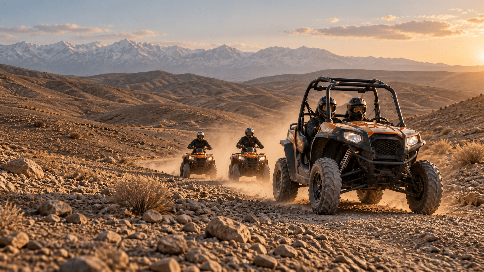 Quad riders and a two-seat buggy crossing a rocky Agafay Desert trail with the Atlas Mountains beyond